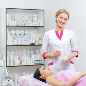 Young woman beautician is doing the cleaning procedure in the beauty salon. Face Skin Care. Cleansing Procedure. Cosmetology.